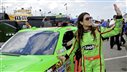 Image: NASCAR Sprint Cup Series driver Danica Patrick (R) waves to fans while rolling her number 10 car out to the track before a practice session for the Daytona 500